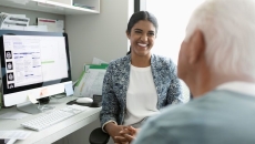 A mental healthcare provider talking to an older patient in the foreground A mental healthcare provider talking to an older patient in the foreground