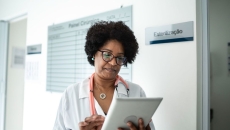 Healthcare provider on a tablet walking through a clinic