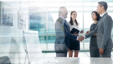 Two people shaking hands while two others watch