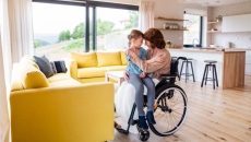 A person in a wheelchair holding a child