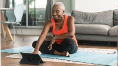 A woman exercising while using a tablet A woman exercising while using a tablet