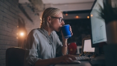 A woman with coffee using her computer