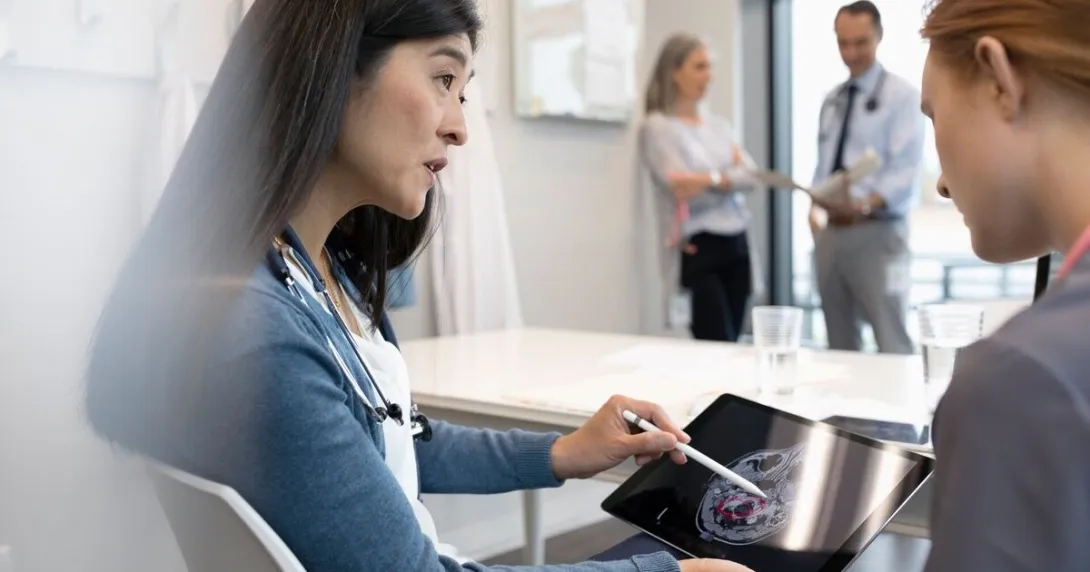 A doctor explaining findings from a brain scan to a patient  A doctor explaining findings from a brain scan to a patient