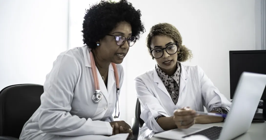 Healthcare professionals reviewing data on a labtop  Healthcare professionals reviewing data on a labtop