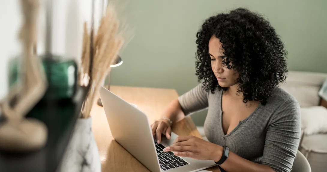 Person sitting at a desk and looking at a computer Person sitting at a desk and looking at a computer
