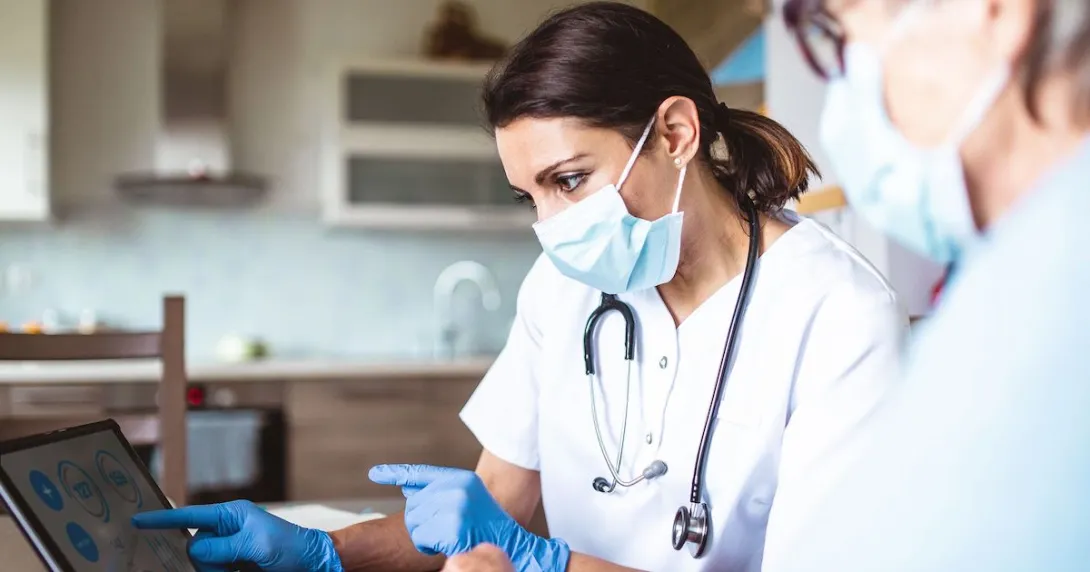 Healthcare provider sitting next to a patient while both are looking at a computer