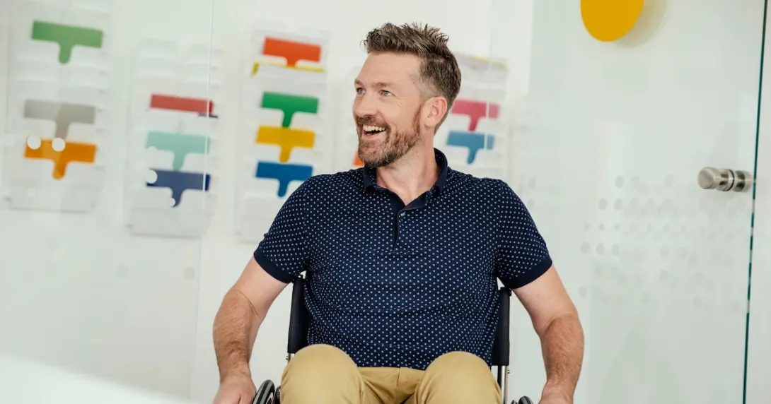 A smiling person in a wheelchair