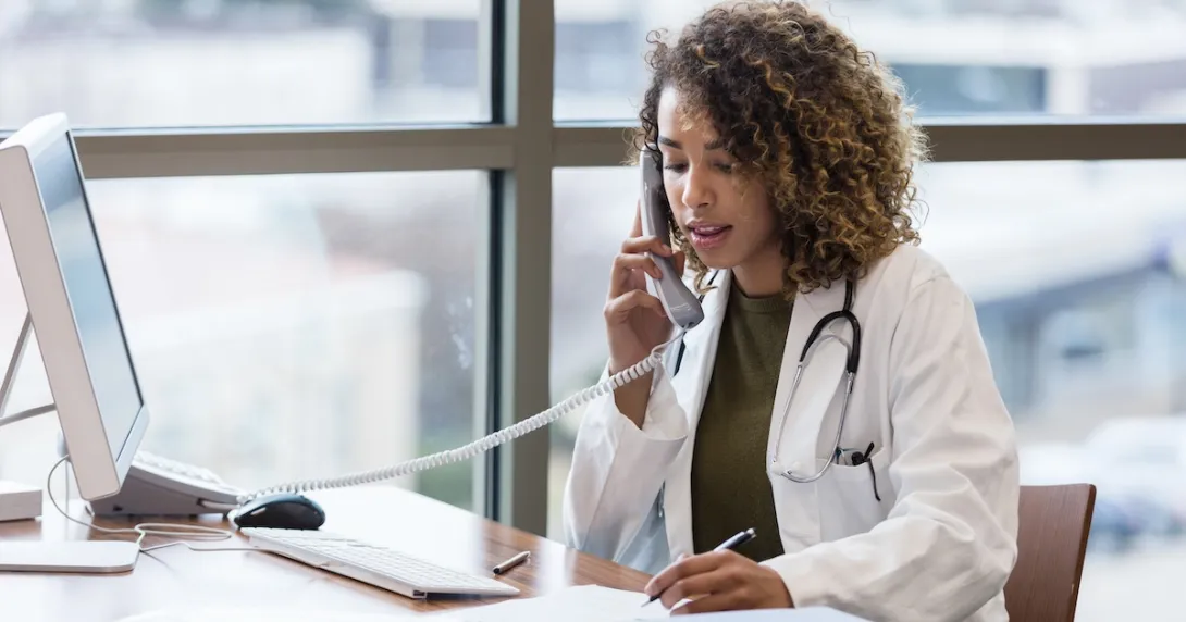 Person sitting at a desk and talking on a phone