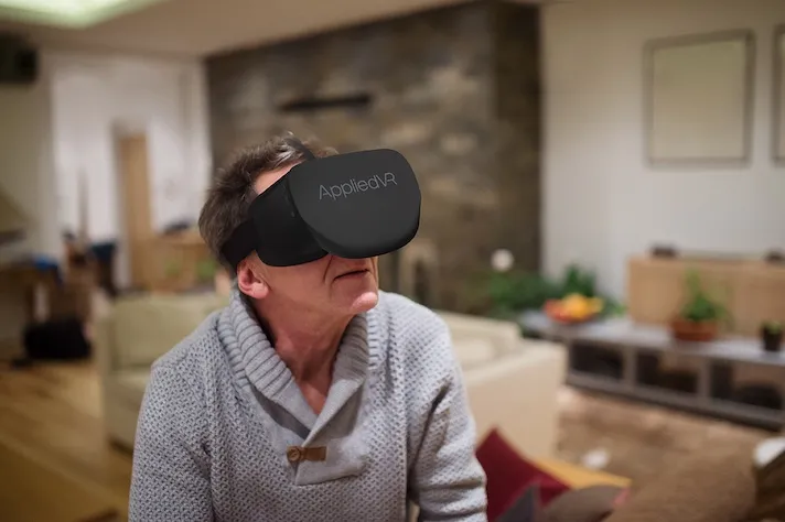 A man using an AppliedVR headset at home. A man using an AppliedVR headset at home.