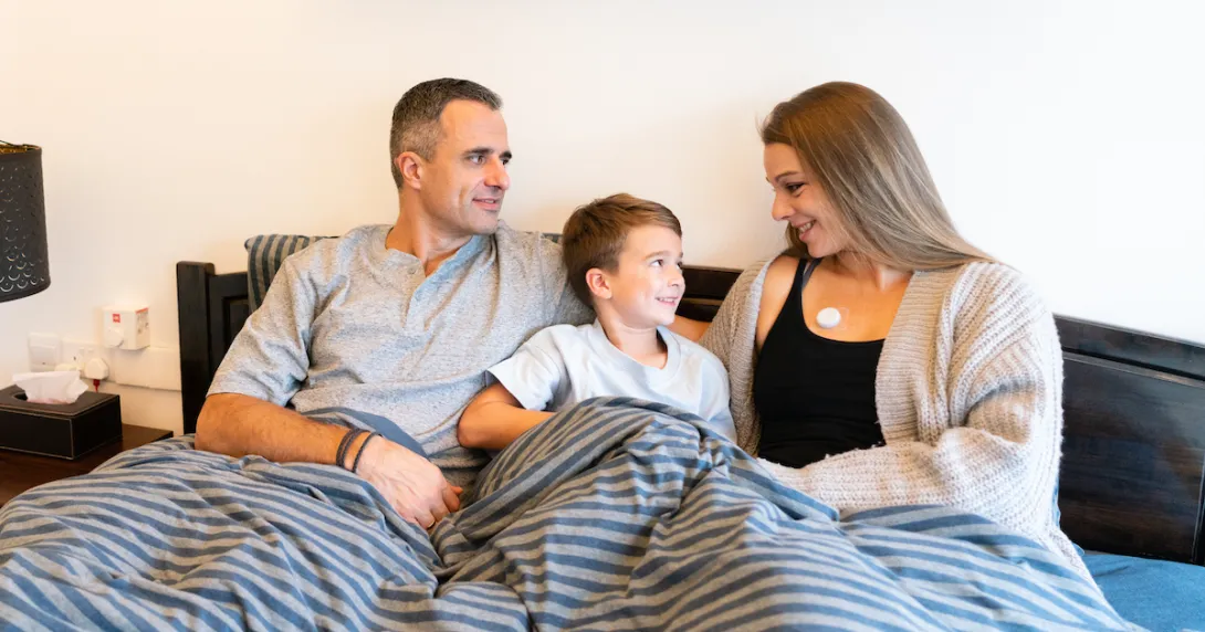A family of three featuring a mother wearing the AeviceMD wearable stethoscope
