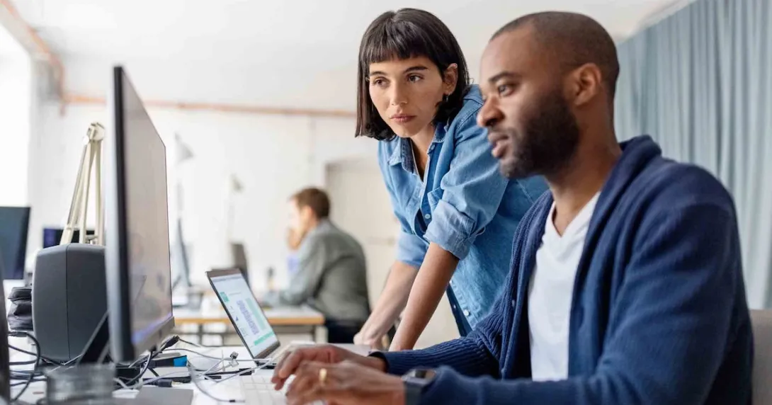 Business people looking at a desktop computer Business people looking at a desktop computer
