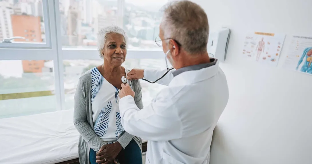 Doctor listening to a patients heart with a stethoscope Doctor listening to a patients heart with a stethoscope