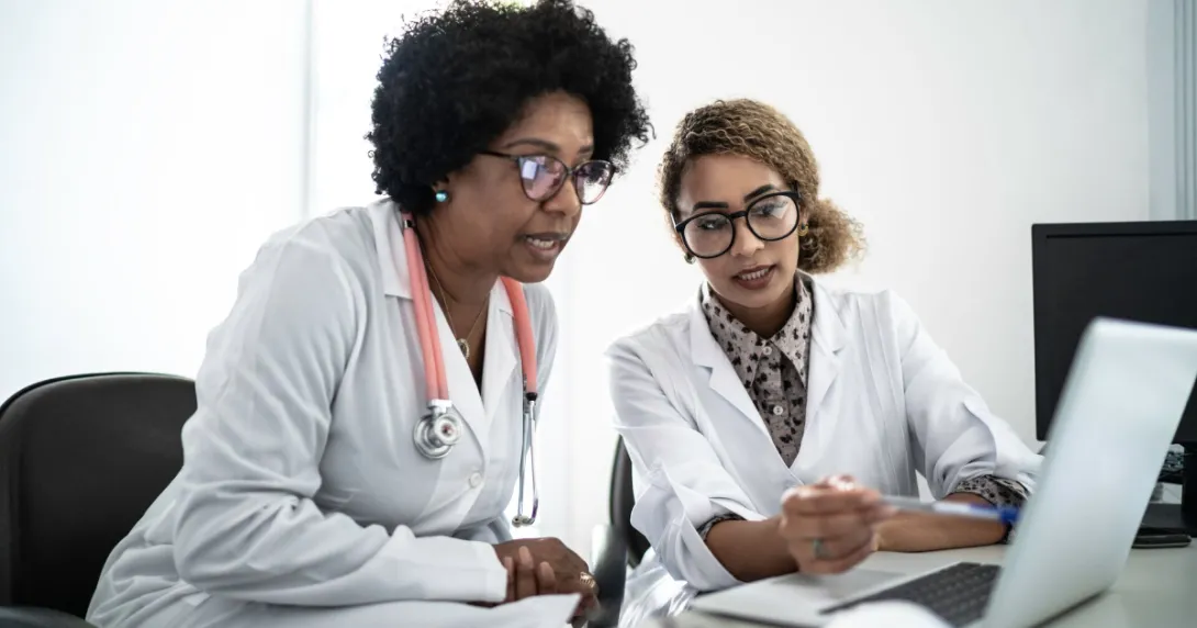 Two healthcare providers on a computer Two healthcare providers on a computer
