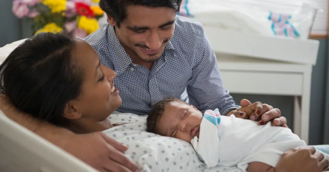 Parents hold infant, one sitting, one laying down Parents hold infant, one sitting, one laying down