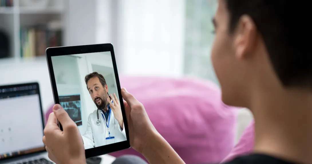 Person on a tablet speaking to a healthcare professional Person on a tablet speaking to a healthcare professional