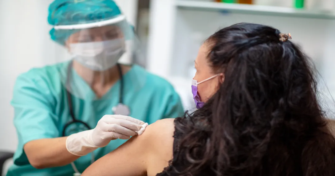 A provider preparing a vaccine for a patient