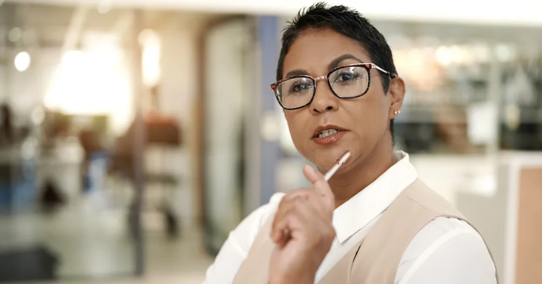 Person sitting in a clinical setting while holding a pen to their chin