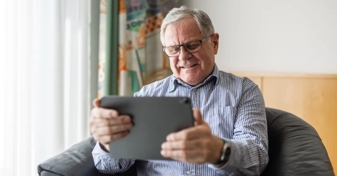 Person sitting in a chair looking at a tablet Person sitting in a chair looking at a tablet
