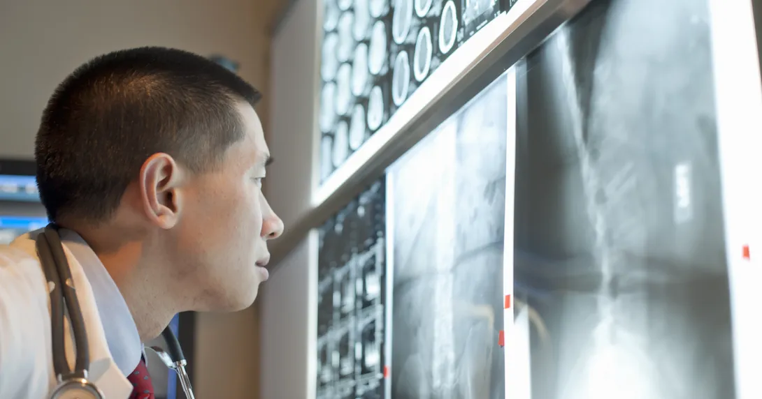 Healthcare provider analyzing diagnostic images hanging on a wall Healthcare provider analyzing diagnostic images hanging on a wall