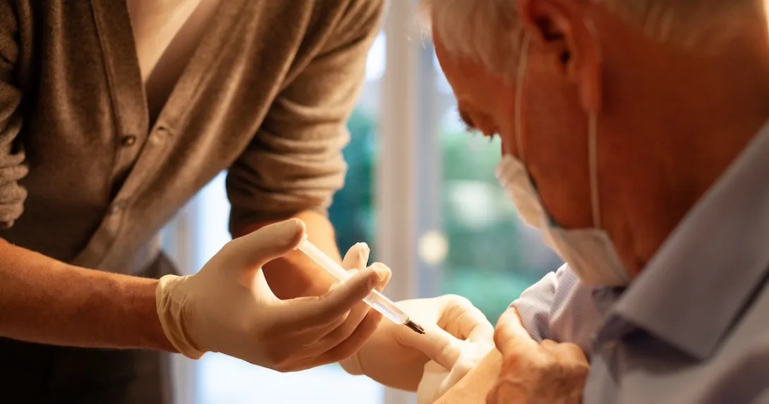 Healthcare practitioners administering injection to patient Healthcare practitioners administering injection to patient