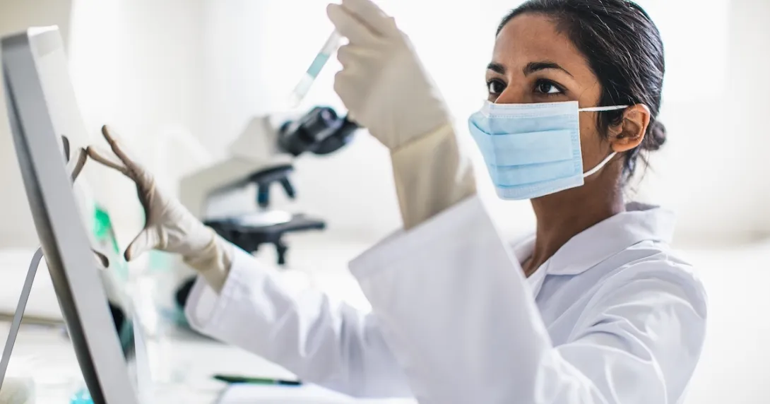 Lab technician examining contents of a test tube Lab technician examining contents of a test tube