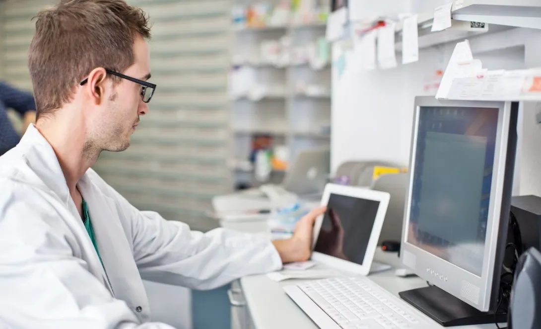 Clinician looking at data on a smart pad  tablet and computer screen