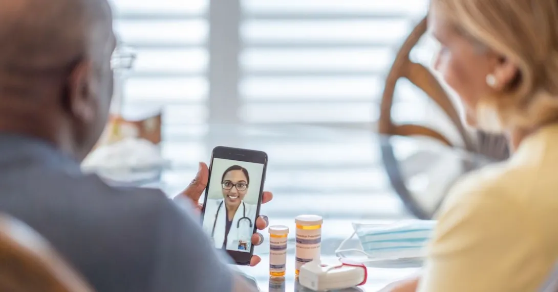 A man and a woman using a smartphone to talk to a provider A man and a woman using a smartphone to talk to a provider