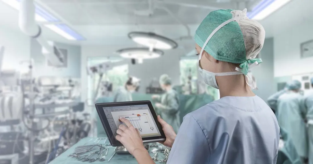 Surgeon in operating room looking at tablet Surgeon in operating room looking at tablet