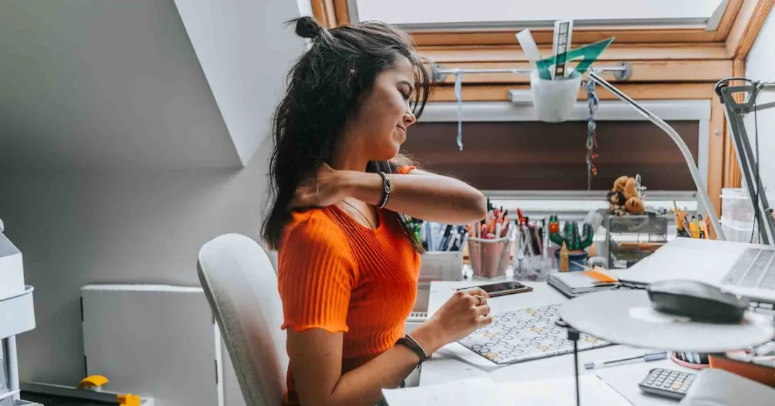 Person grabbing their shoulder due to discomfort Person grabbing their shoulder due to discomfort