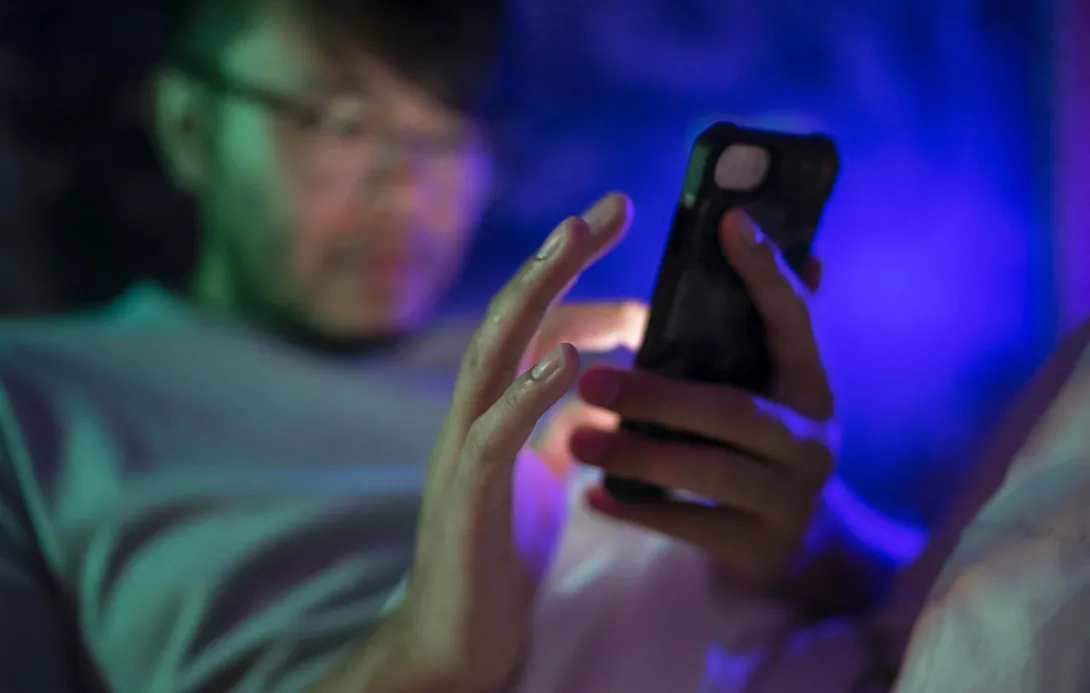A man using a smartphone at night. A man using a smartphone at night.