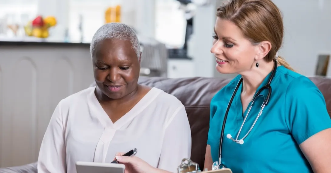 Clinician reviewing healthcare information with a patient with a tablet Clinician reviewing healthcare information with a patient with a tablet