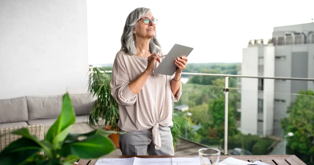 Person on a balcony looking at a tablet Person on a balcony looking at a tablet