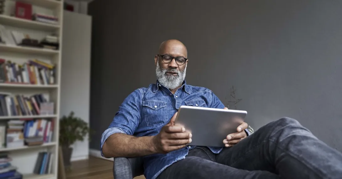 Person sitting in a chair while looking at a tablet Person sitting in a chair while looking at a tablet