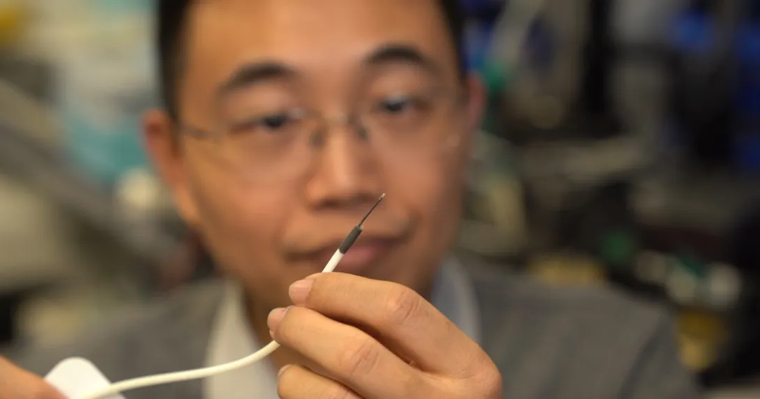 A researcher holding a small-scale surgical robot A researcher holding a small-scale surgical robot