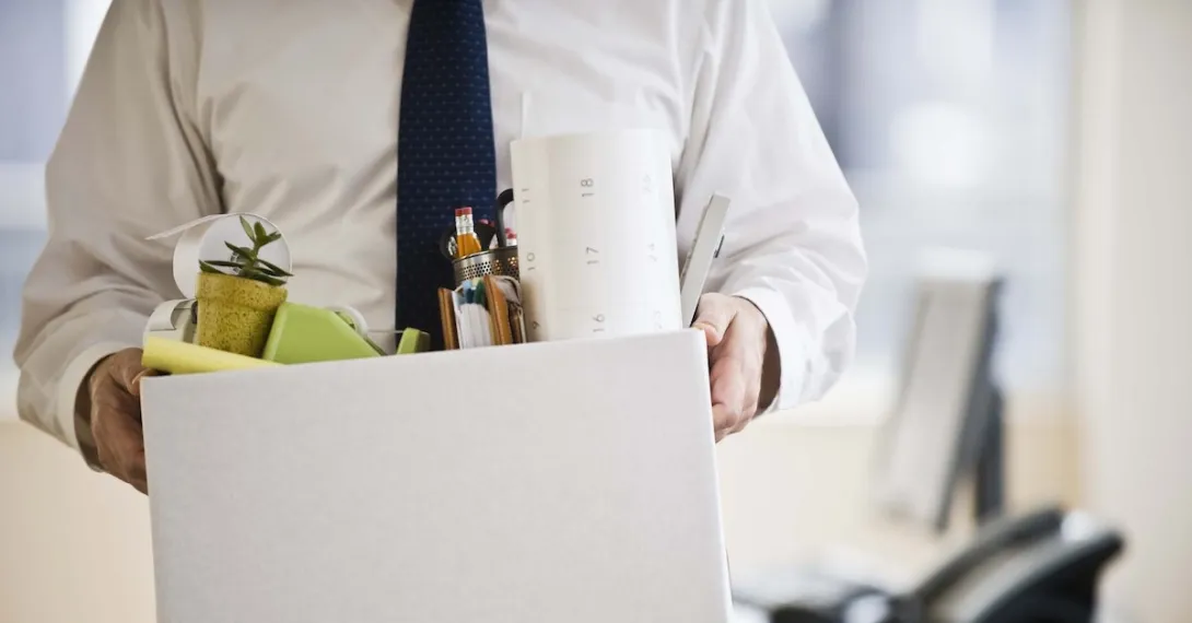 A worker holding a box with belongings A worker holding a box with belongings