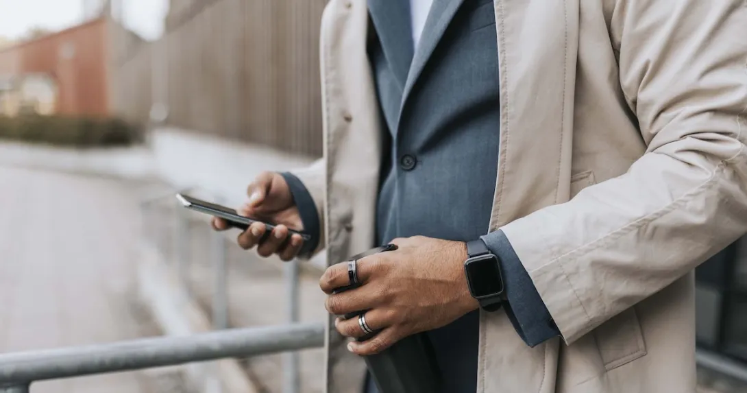 Midsection of a person in a suite wearing two rings and looking at their phone Midsection of a person in a suite wearing two rings and looking at their phone