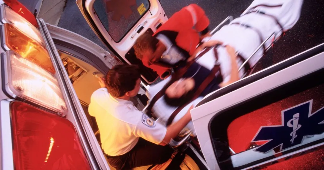 Paramedics rolling a patient onto an ambulance. Paramedics rolling a patient onto an ambulance.
