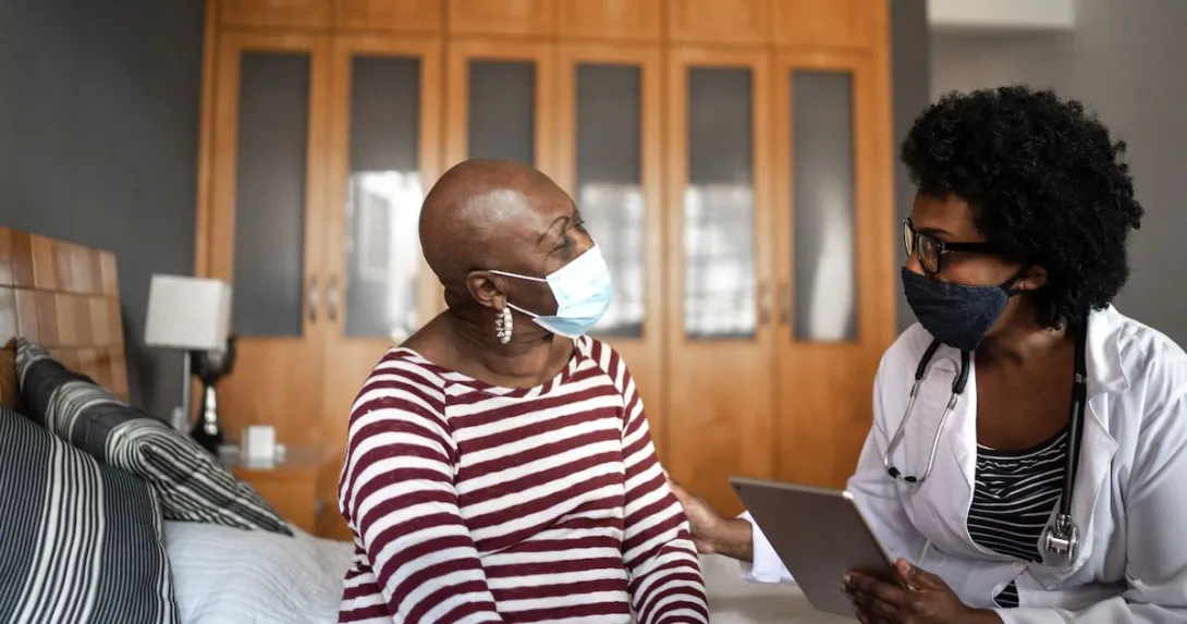 A cancer patient talking to a provider in her home. A cancer patient talking to a provider in her home.