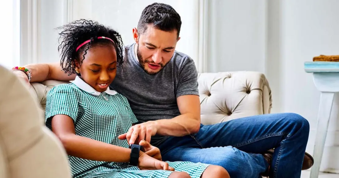 A child setting up a smartwatch with a parent A child setting up a smartwatch with a parent