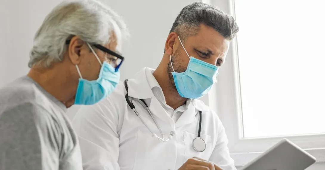 A medical professional and a patient talking to another provider using a tablet. A medical professional and a patient talking to another provider using a tablet.