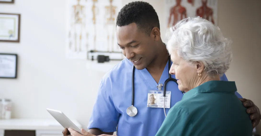 A doctor and a patient looking at information on a tablet. A doctor and a patient looking at information on a tablet.