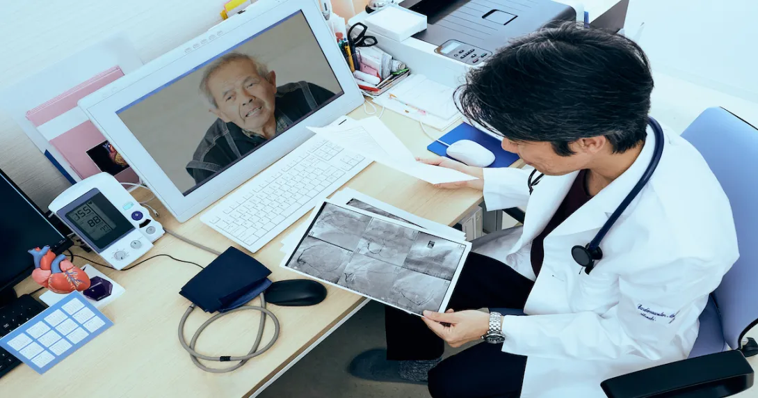 A doctor speaking with a patient using telehealth and looking at imaging results. A doctor speaking with a patient using telehealth and looking at imaging results.