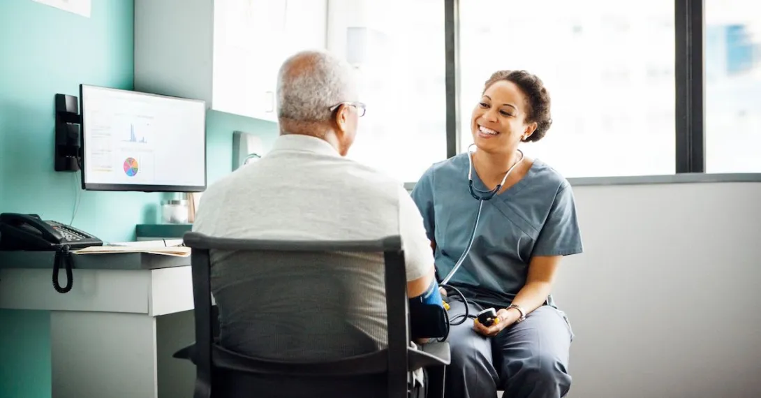A provider talking to a patient while taking his blood pressure. A provider talking to a patient while taking his blood pressure.
