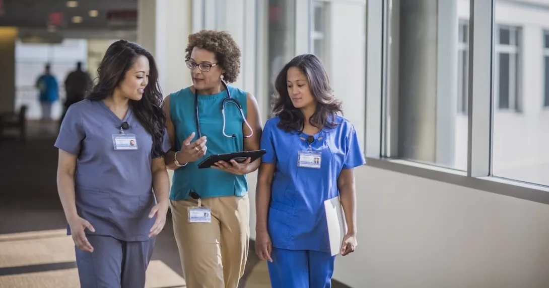 Three healthcare professionals conversing Three healthcare professionals conversing