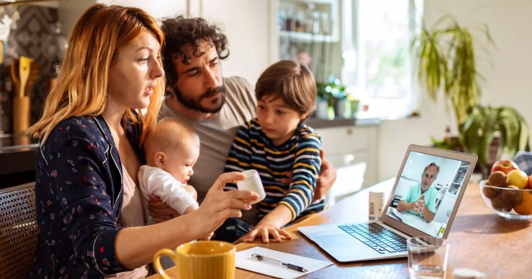 A family talking to a doctor through a video chat on a laptop. A family talking to a doctor through a video chat on a laptop.