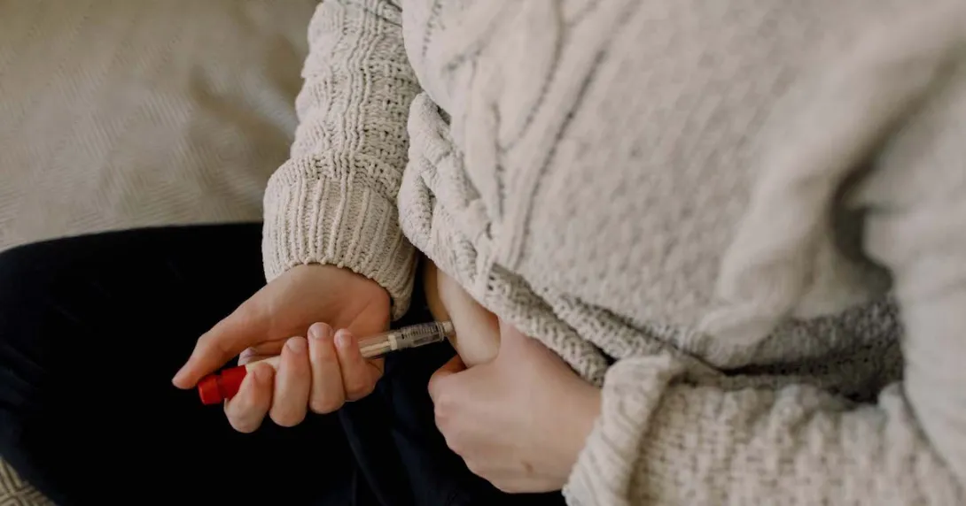 A close up of a person injecting fertility medication into their abdomen A close up of a person injecting fertility medication into their abdomen
