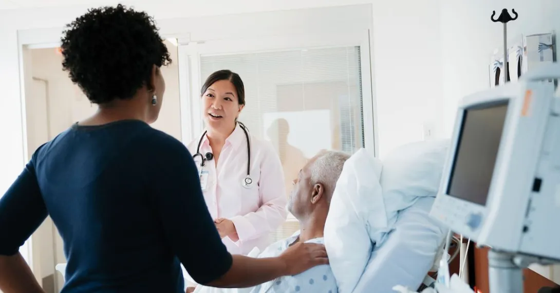 A doctor talking to patient and his family in a hospital room. A doctor talking to patient and his family in a hospital room.