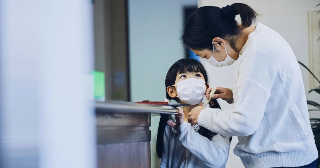 A mom checks a child's temperature before he goes to school A mom checks a child's temperature before he goes to school