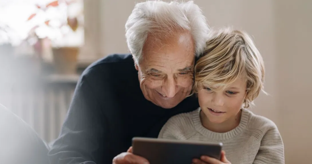 An adult and a child using a tablet together An adult and a child using a tablet together