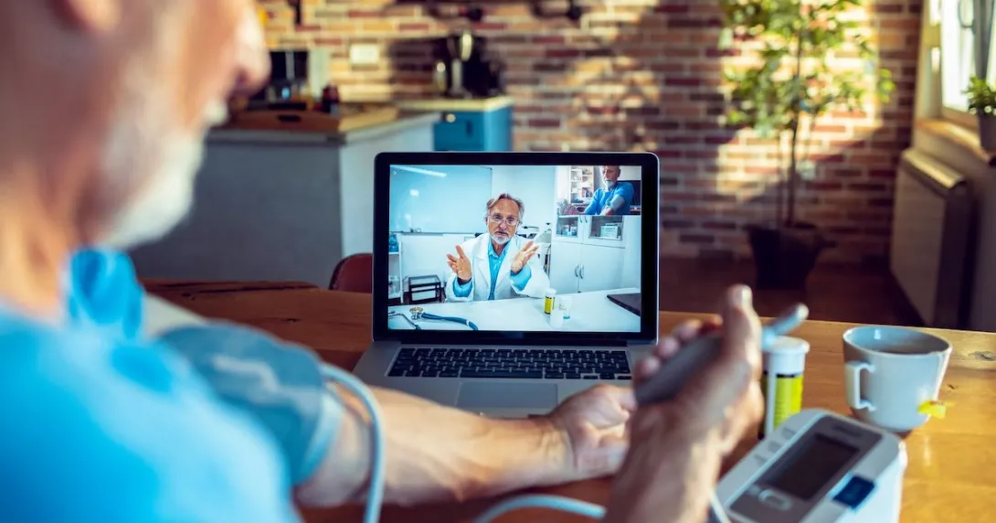 Patient taking their blood pressure while on a video call with a provider Patient taking their blood pressure while on a video call with a provider